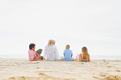 一个白人家庭坐在海滩上图片素材