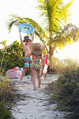 美国佛罗里达州萨尼贝尔海滩，男孩和两个姐妹在玩和收集贝壳图片素材