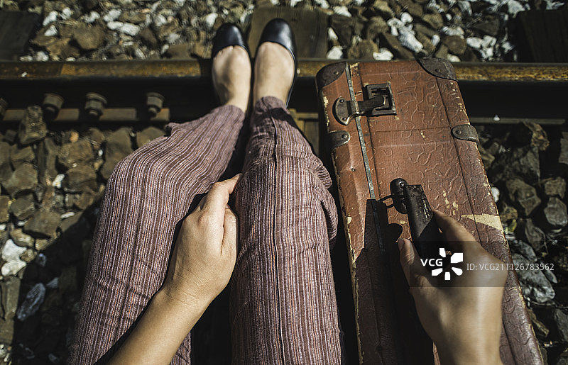 鐵路上的女人和老式行李箱圖片素材