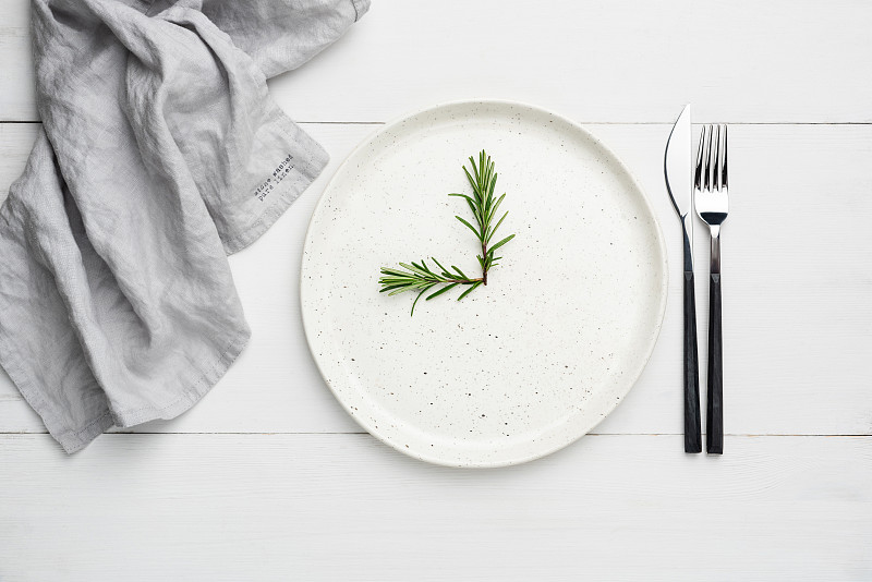 白色的盤子和餐具放在白色的木板上，食物背景圖片素材