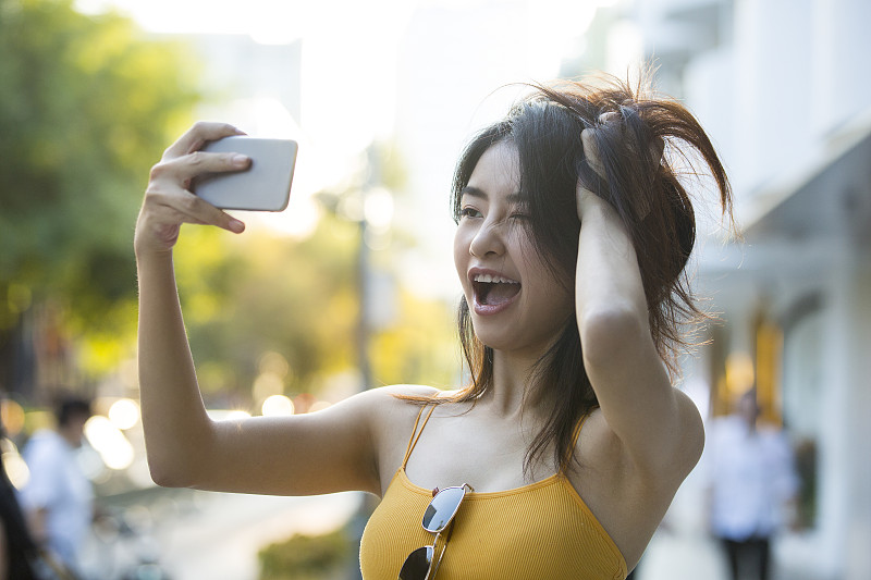 青年女子在户外旅行度假用手机拍照做网络直播图片下载