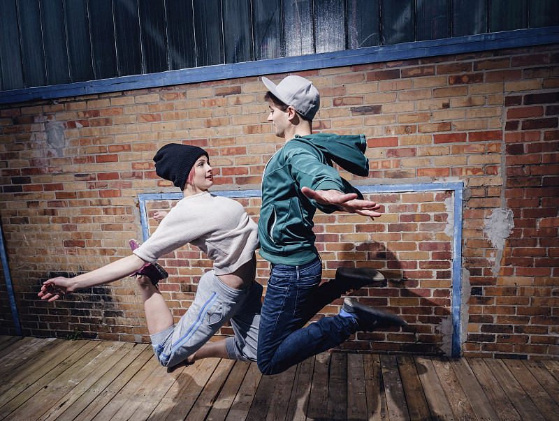 現代舞演員靠磚墻表演圖片素材