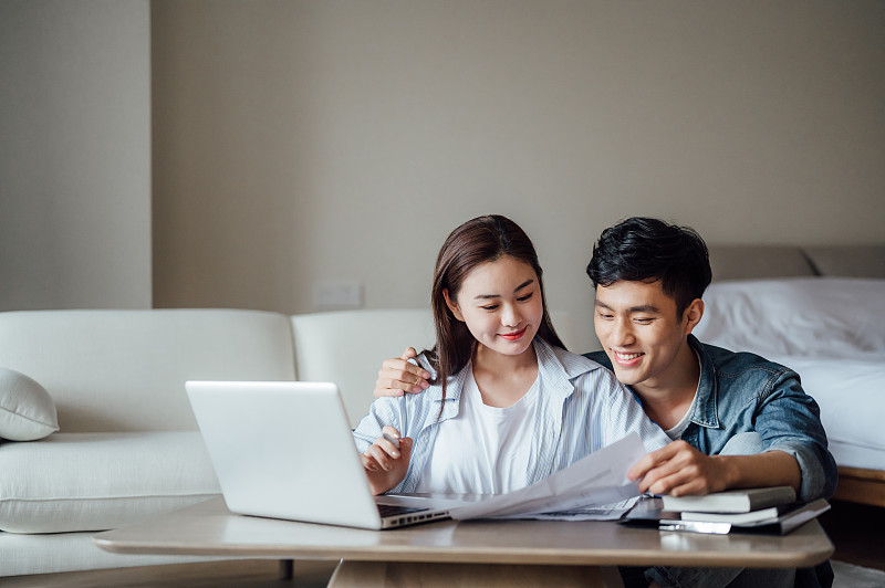 亞洲年輕情侶在家使用電腦看戶型圖圖片下載
