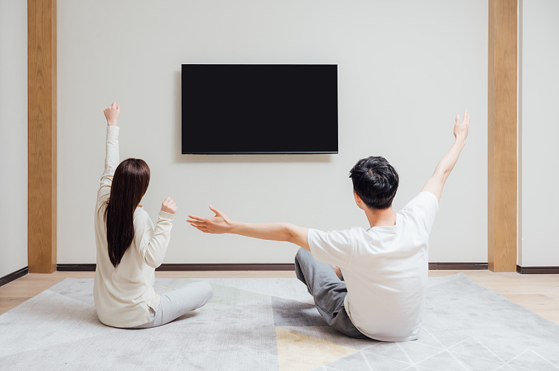 亞洲年輕情侶在家看電視圖片素材