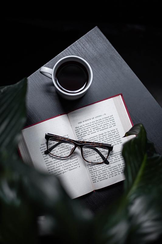 高角度视角的眼镜与书和咖啡杯在桌子上，印度尼西亚图片下载