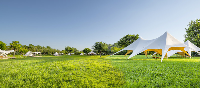 公园里的绿色草地上搭着露营帐篷图片下载