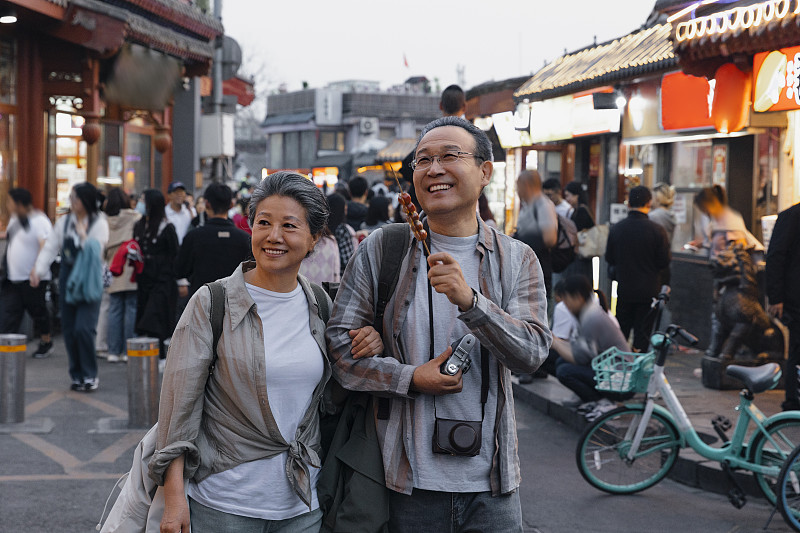 老年人City walk系列:老年夫妇在北京什刹海胡同商业街旅行图片下载
