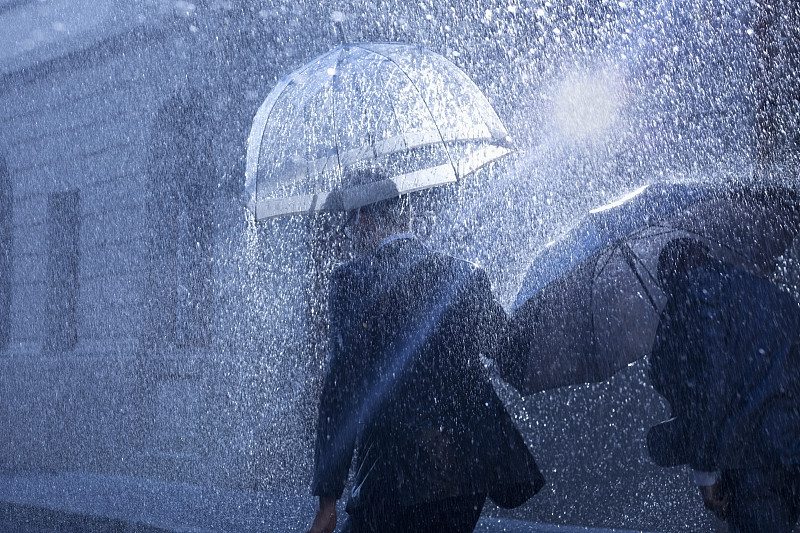 商人在雨中打着雨伞图片下载