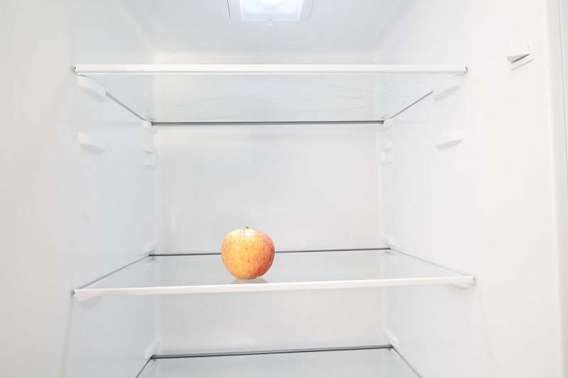 冰箱里只有一個蘋果。圖片素材