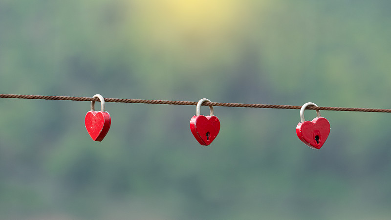 3把紅色的心形鑰匙掛在代表愛情的箭頭上圖片下載
