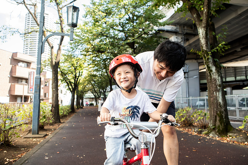 一個男孩從他父親那里學騎自行車圖片素材