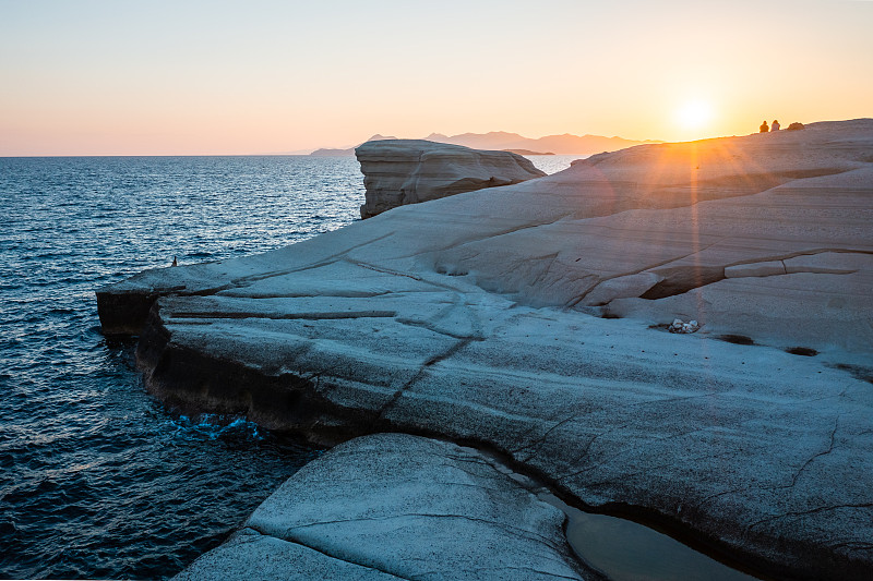日落時分，希臘米洛斯的Sarakiniko海灘上有白色的巖石攝影圖片