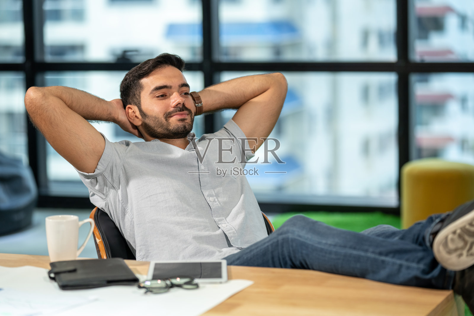 快乐年轻的白人商人办公室工作人员坐在现代办公室的椅子上休息。帅哥创意自由职业者放松和午睡在工作场所。照片摄影图片