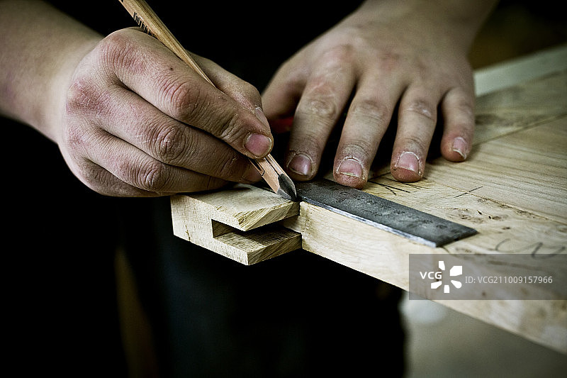 伐木工人在木材上工作的人，用尺子和铅笔测量接缝或角图片素材