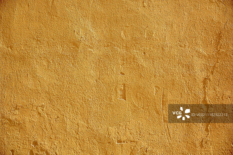 背景和纹理概念-黄色漆石墙面。漆成黄色的石头墙面图片素材