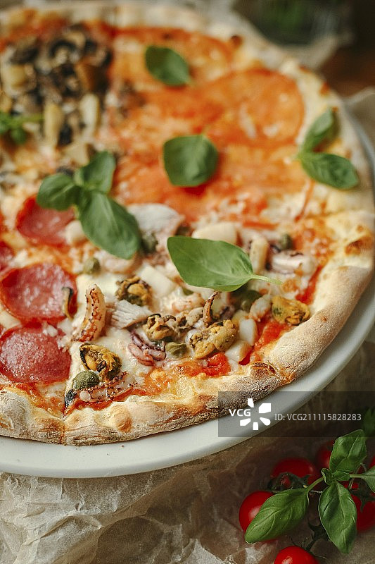 披萨加意大利腊肠，海鲜，西红柿和蘑菇图片素材