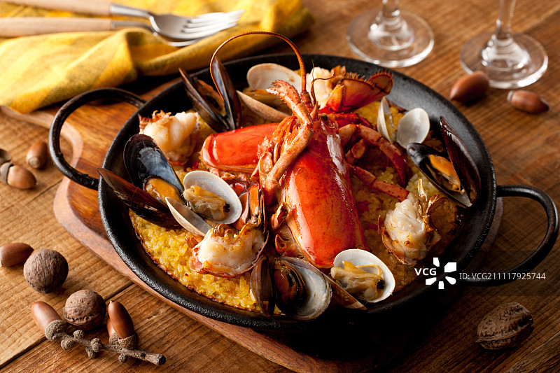 黄色餐布旁边的龙虾海鲜饭图片素材