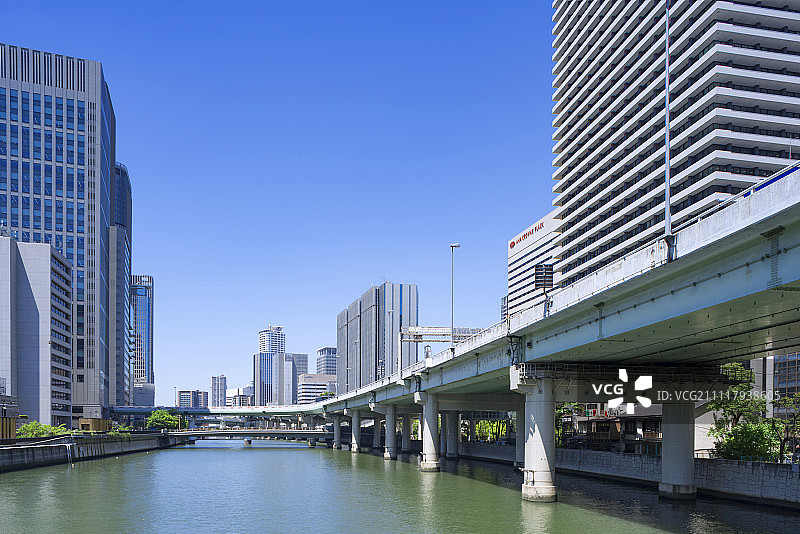 日本大阪市岛岛河上大桥上的中之岛/岛岛摩天大楼与城市高速公路图片素材