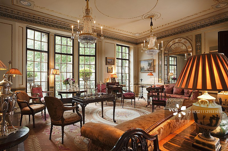 路易十六水晶吊灯，古董红木家具和格鲁吉亚的软垫沙发，新古典主义沙龙图片素材