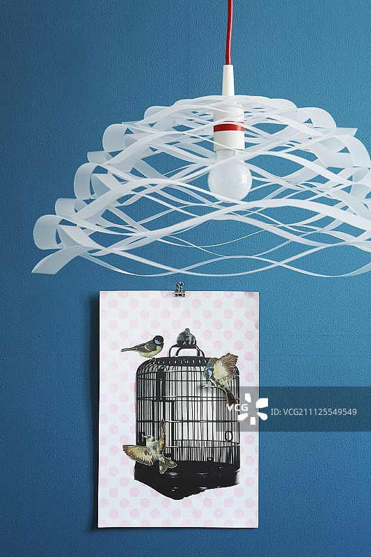 通风，纸吊灯前的剪纸鸟和鸟笼拼贴在蓝色的墙壁上图片素材