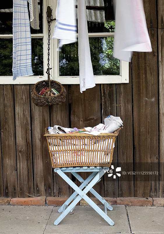 乡村木屋外，折叠凳上的洗衣篮图片素材