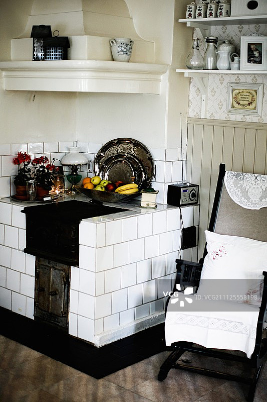 旧厨房椅与坐垫旁边的砖石厨房炉与白色瓷砖在角落图片素材
