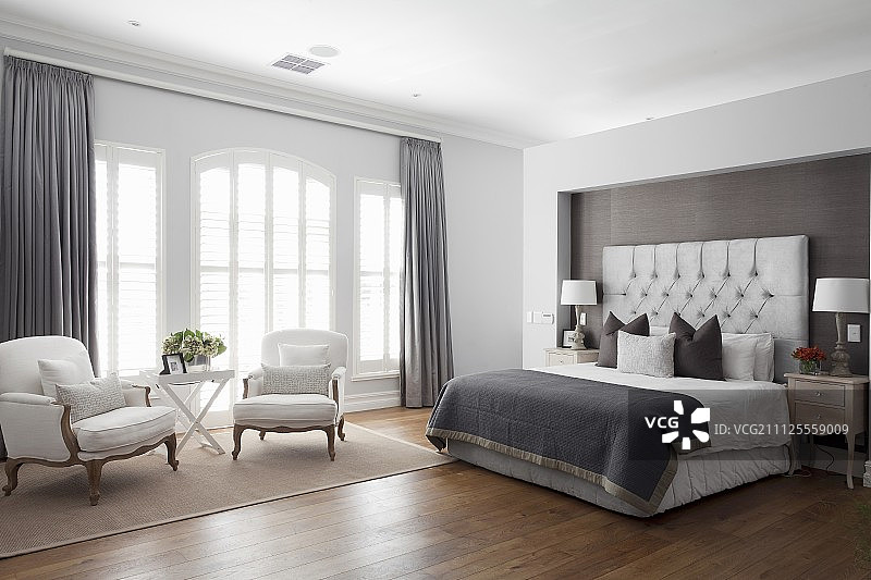 卧室有优雅的双人床壁龛在隔墙和洛可可扶手椅在休息室在窗前图片素材