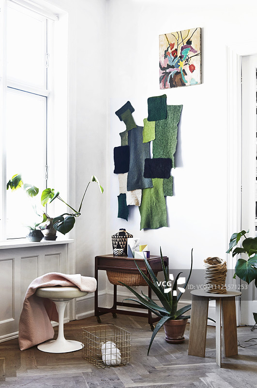 在斯堪的纳维亚时代的公寓里，用绿色的织物残余拼贴和偶尔的家具图片素材