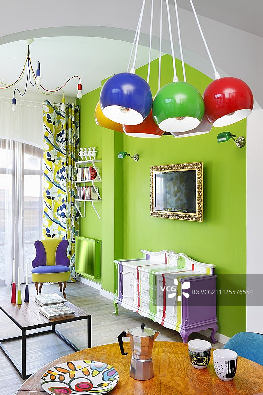 色彩丰富的生活区有霓虹灯绿色的墙壁，粉刷的古色古香的橱柜和色彩鲜艳的球形灯具图片素材