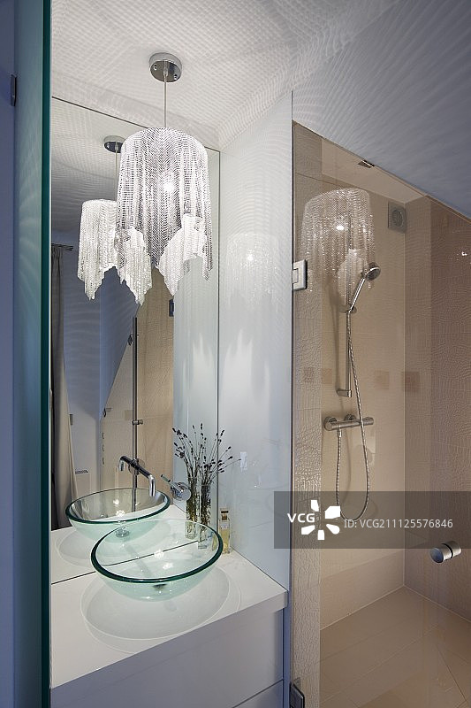 优雅的浴室，淋浴，高镜子和吊灯与闪闪发光的织物灯罩图片素材