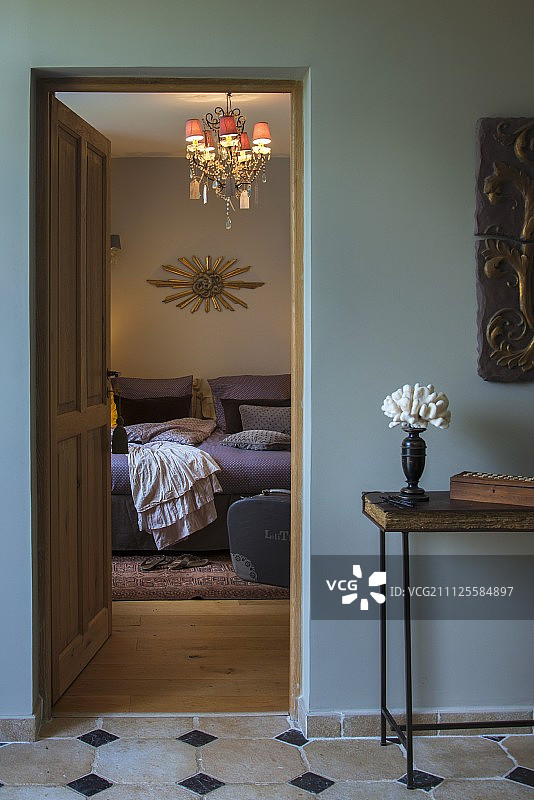 从卧室的开放式门可以看到床上方的小灯罩吊灯图片素材