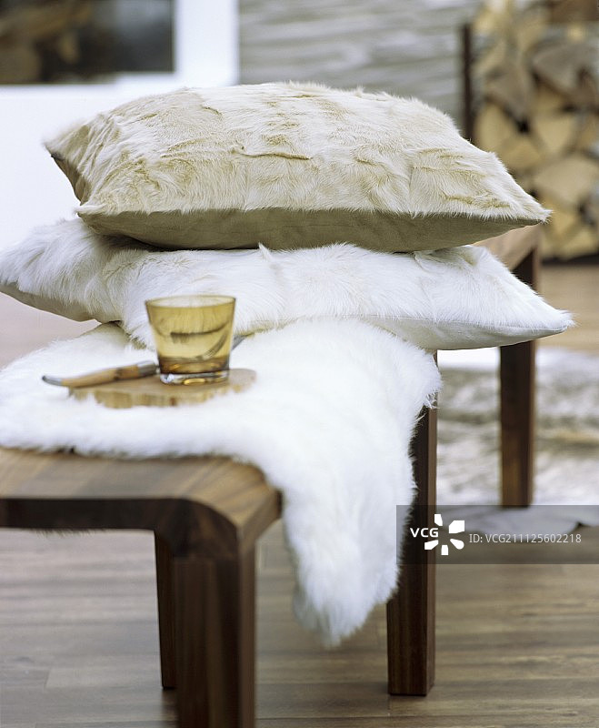 木凳上有毛皮垫子和羊皮毯子图片素材