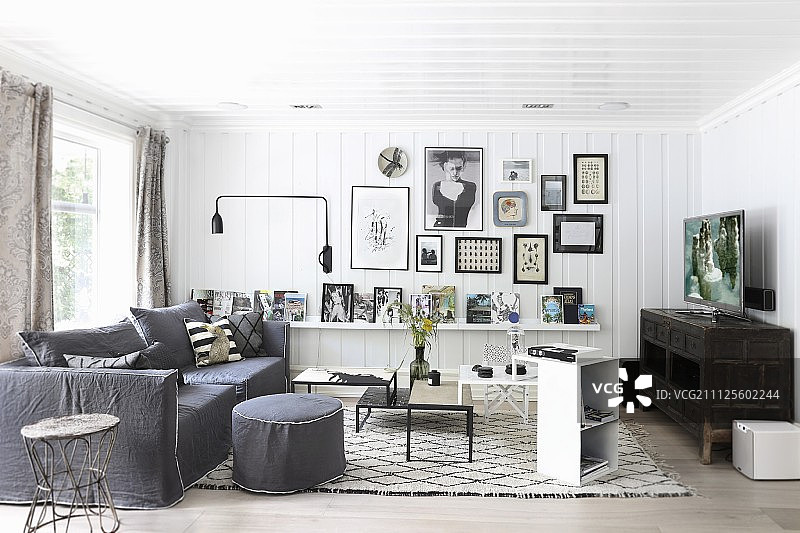 斯堪的纳维亚风格的室内，白色的木质墙壁，灰色的扶手椅和沙发旁边的咖啡桌图片素材