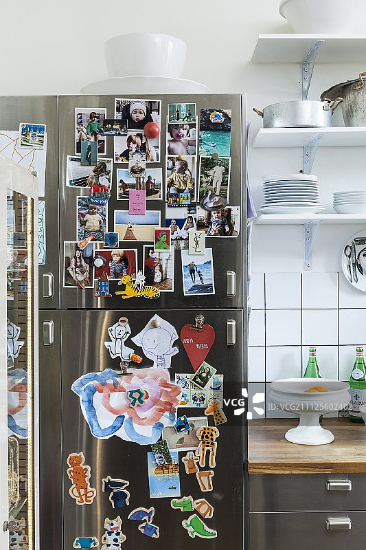 一组照片贴在不锈钢冰箱上，贴在厨房柜台和壁挂式的架子上图片素材