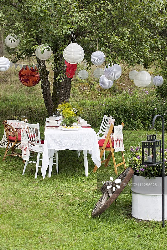花园餐桌为瑞典小龙虾聚会设置灯笼挂在树上图片素材