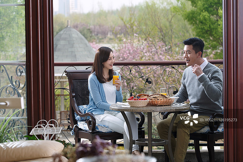 中年夫妇在阳台上吃早餐图片素材