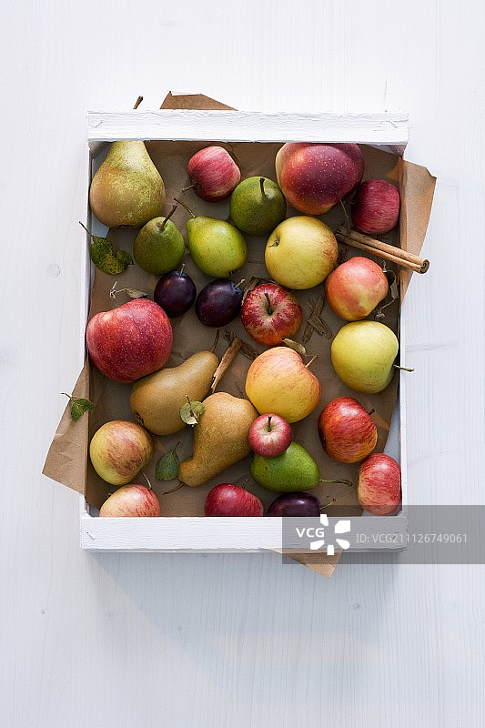 苹果、梨、李子和肉桂放在一个板条箱里图片素材