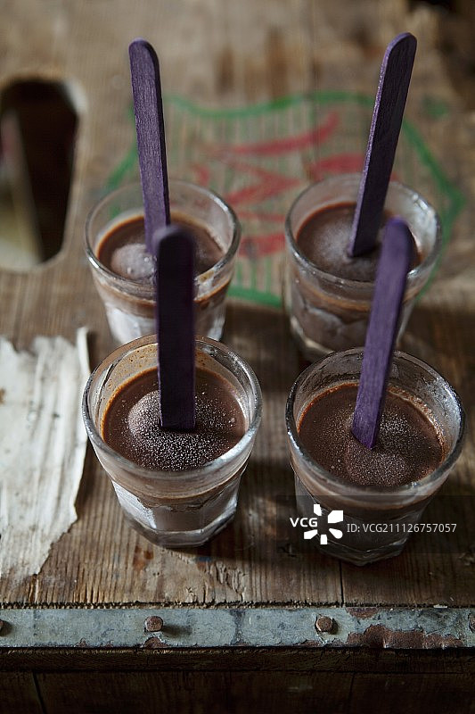 四个巧克力射手，巧克力冰淇淋棒放在小酒杯里图片素材