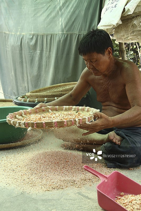 泰国，一个正在清洗干虾的小贩图片素材