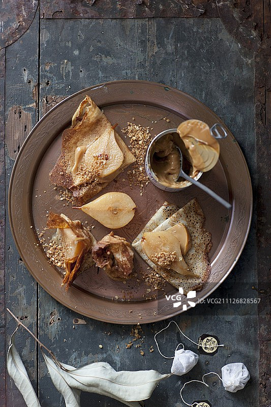 可丽饼配水煮梨，焦糖和澳洲坚果屑图片素材