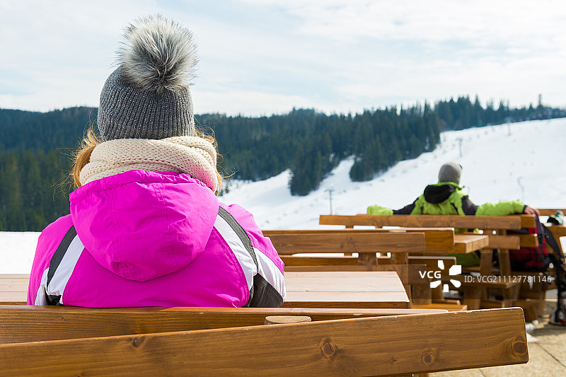 滑雪者坐在滑雪场的户外酒吧，欣赏风景图片素材