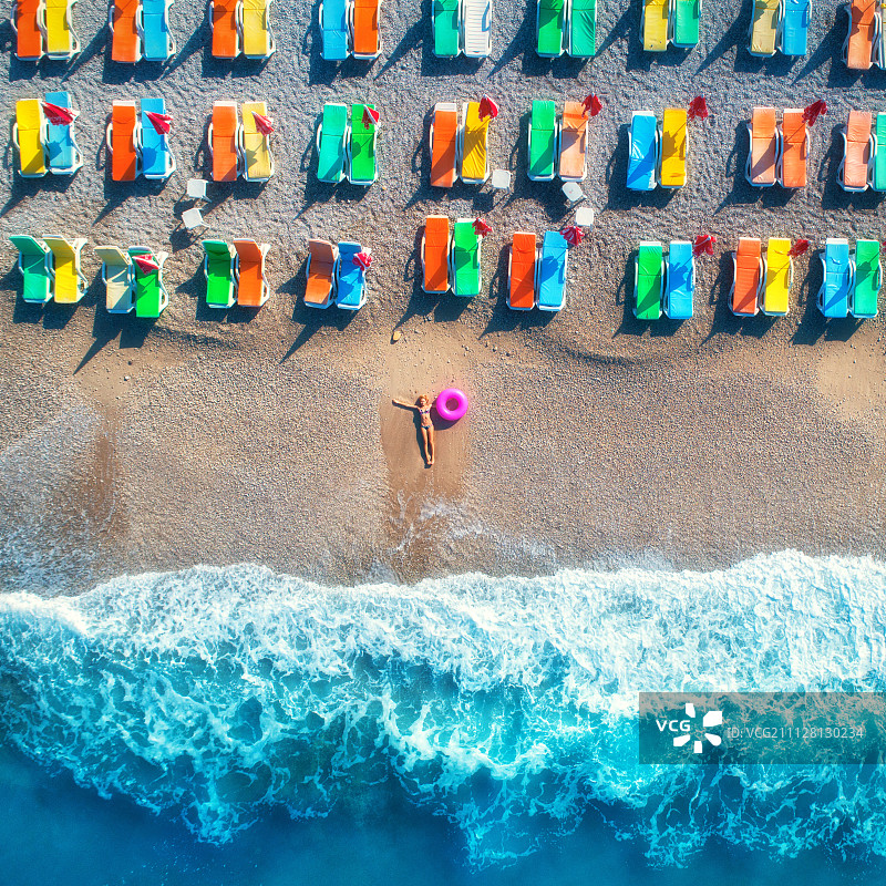 鸟瞰躺着的女人与游泳环在海里图片素材