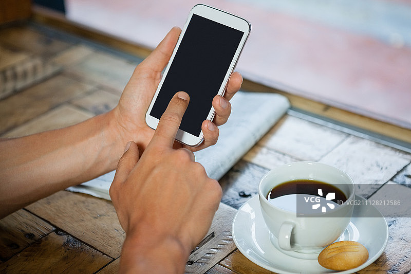 桌子上的一个女人拿着咖啡杯的手机图片素材