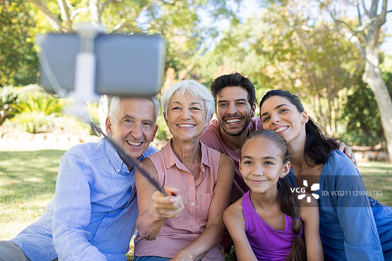 一家人微笑着在公园里自拍图片素材