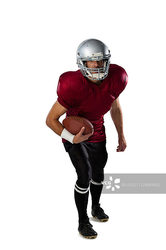 全长度的美国足球运动员戴着头盔站在白色的背景图片素材