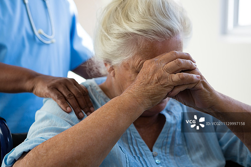护士在养老院安慰老年妇女的腹部图片素材