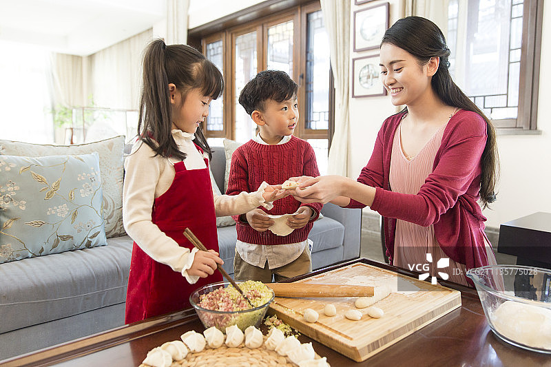 快乐妈妈和男孩女孩庆新年包饺子图片素材