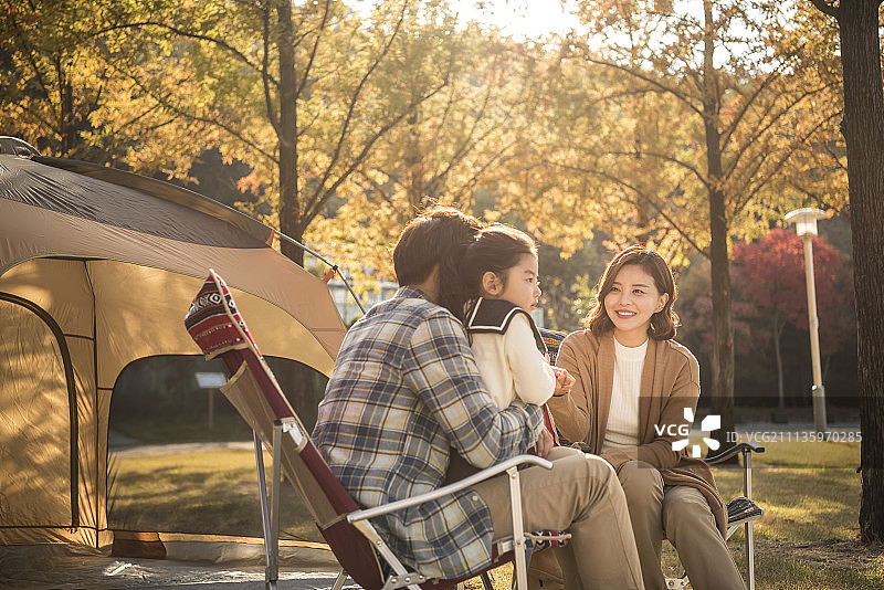 秋天一家人坐在公园的躺椅上野餐的照片图片素材