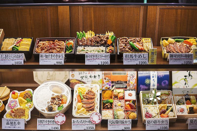 高角度的选择便当盒与传统的日本食品在架子上。图片素材