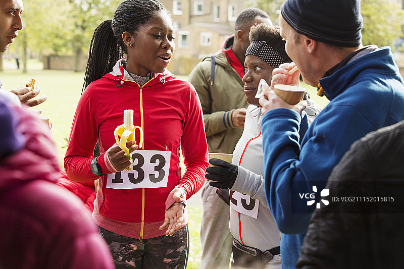 跑步者在公园的慈善比赛中喝水和吃香蕉图片素材